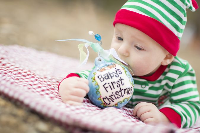 Infant Baby On Blanket With Babys First Christmas Ornament