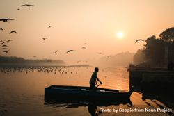 Man on paddling boat during golden hour 0yOra4