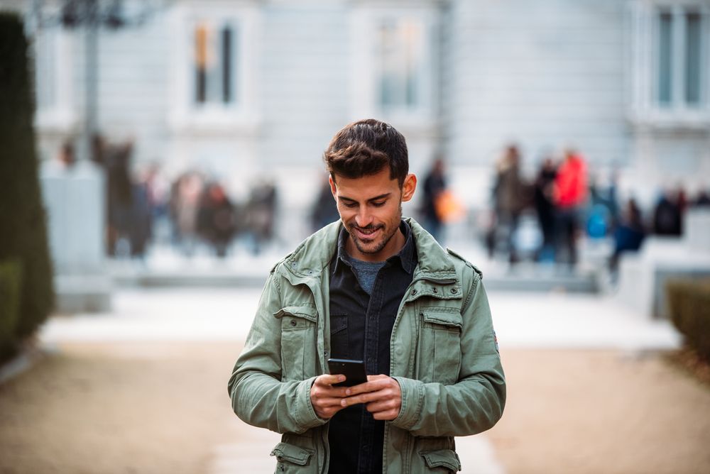 Young man on the mobile phone and walking