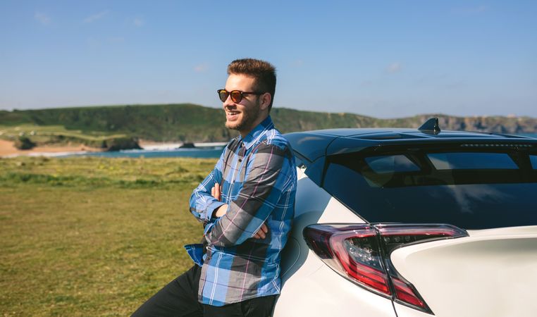 young man leaning on his car