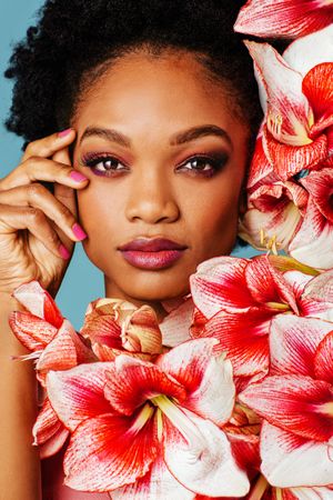 Studio shoot of Black woman surrounded by flowers