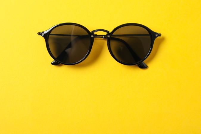 Sunglasses on color background, space for text and closeup. Fashionable accessories