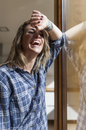 Woman at home leaning in a windows