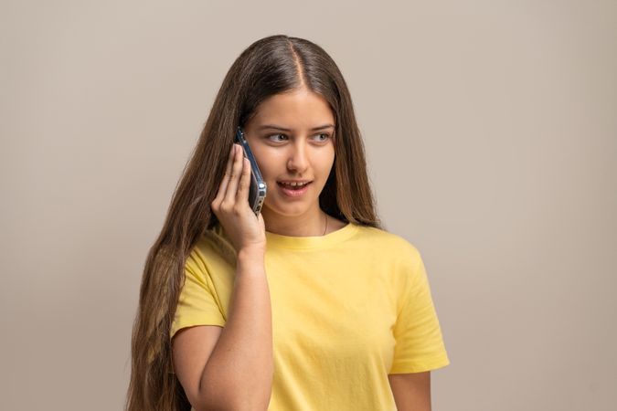 Young woman talking on the phone, having a pleasant conversation.