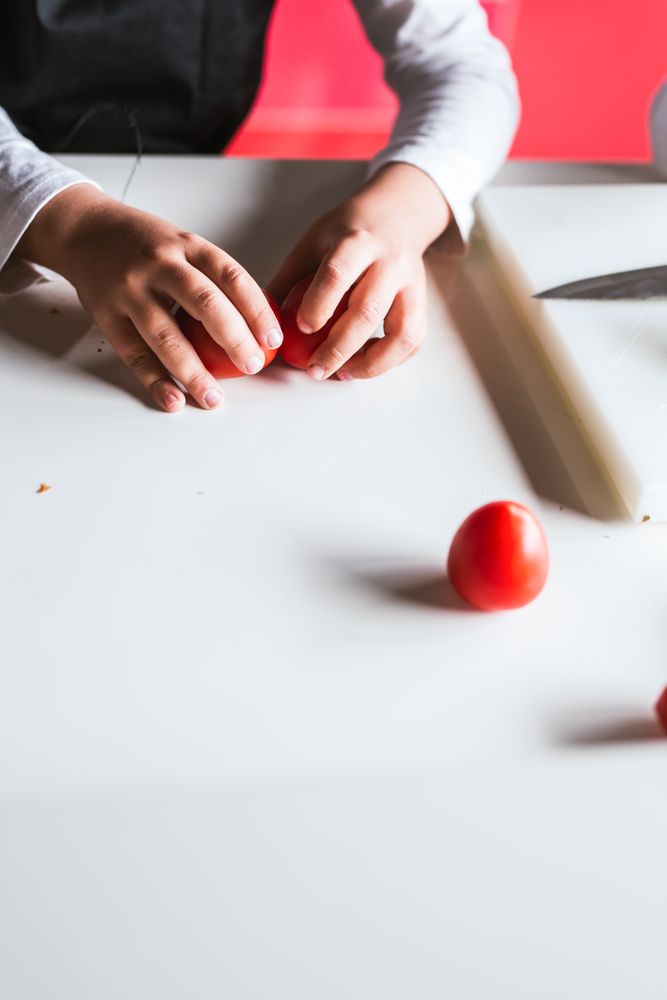Anonymous boy preparing vegetables for salad
