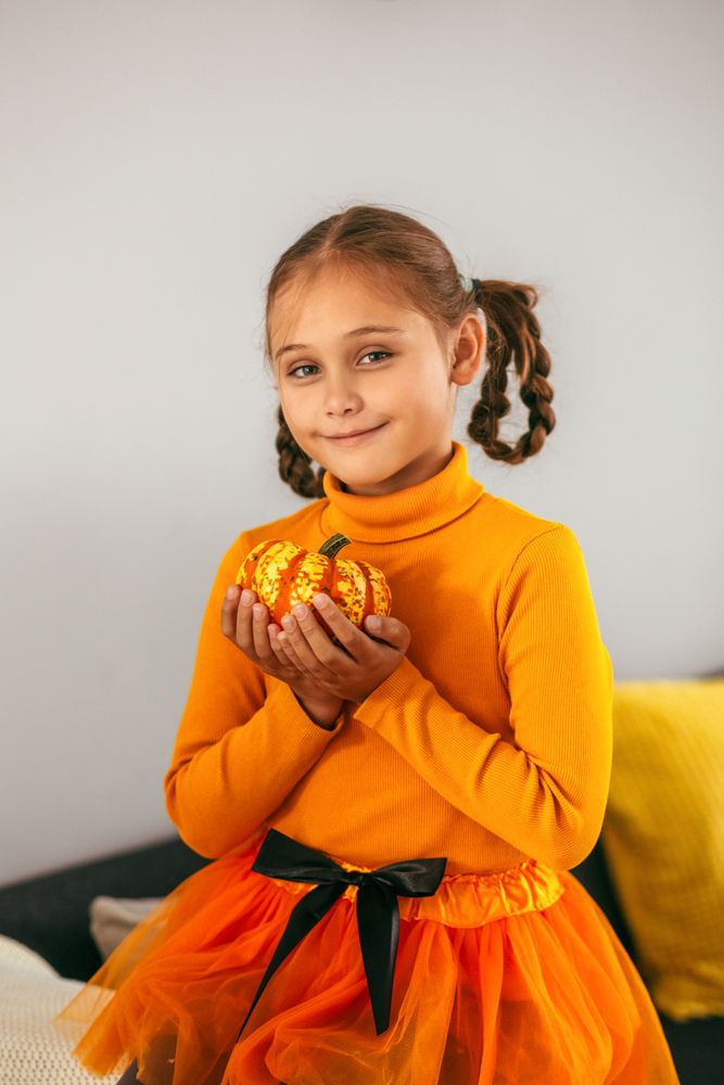 Little Girl Playing With a Pumpkin.