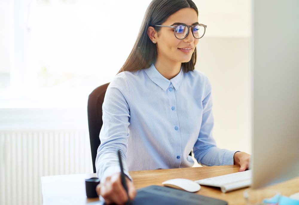 Woman working in bright office using stylus on digital tablet
