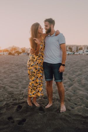 Lovely couple standing hugging on sandy beach