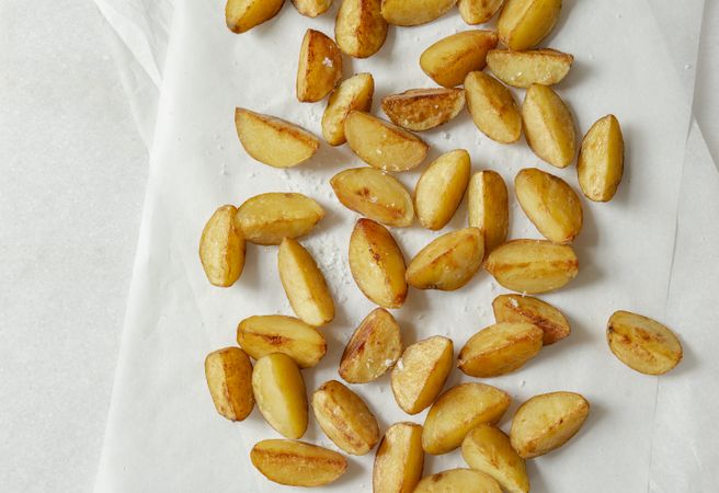 Potato wedges with salt on light background