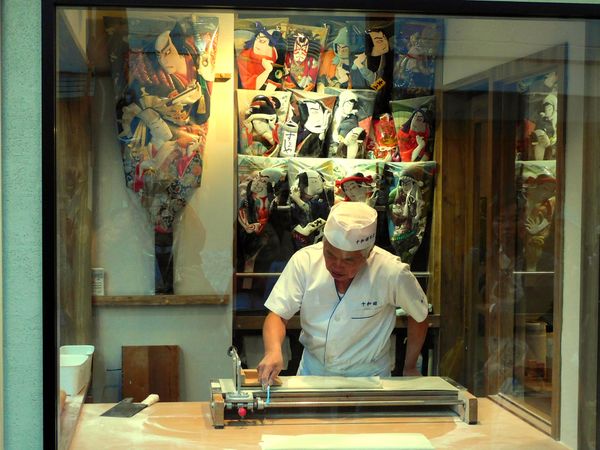Man working in a shop with Chinese decoration