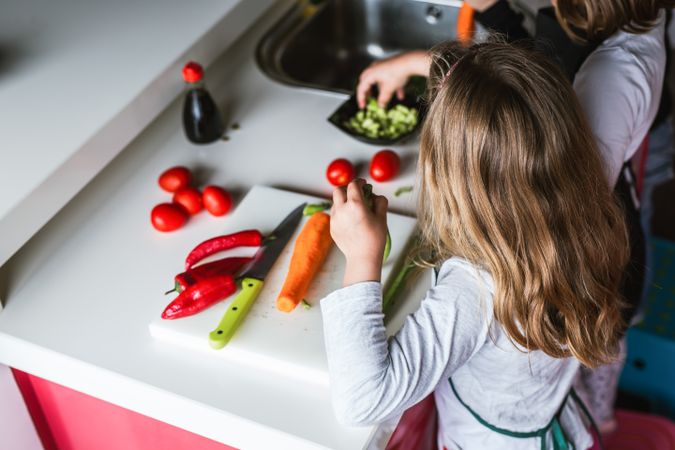 Siblings preparing vegetables for salad