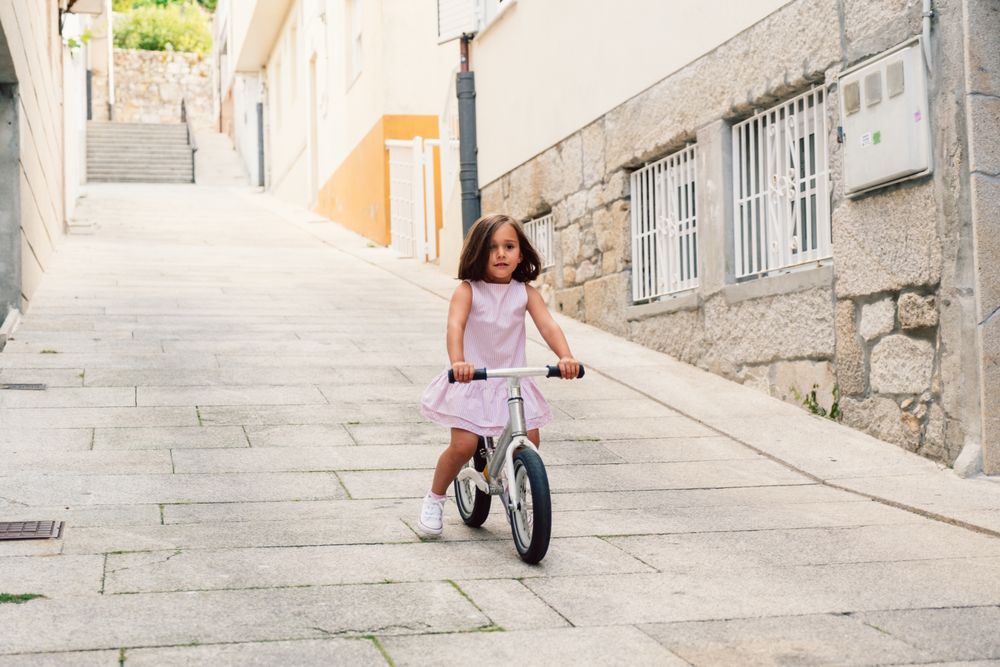 Girl riding on bicycle in narrow street