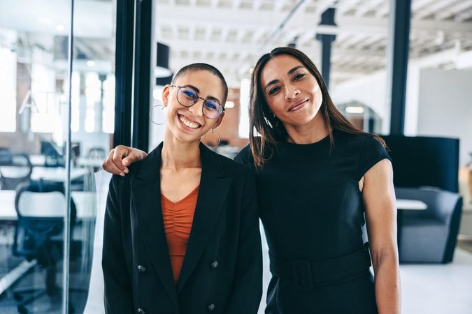 Female colleagues standing together in a modern workplace