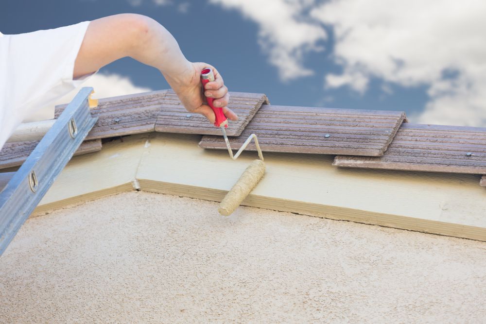Professional Painter Using Small Roller to Paint House Fascia