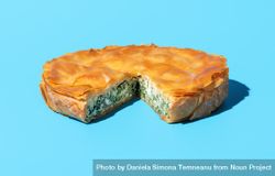 Phyllo cake with spinach and feta cheese, isolated on a blue background 0Jr8v0