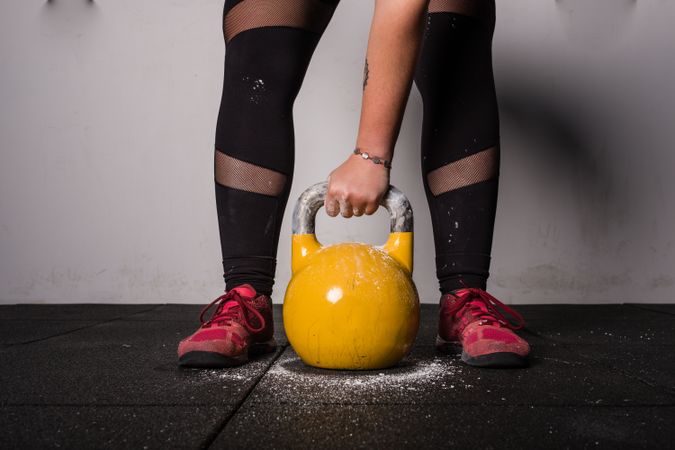 woman lifting kettlebell in gym