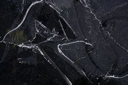 Fragment of thin ice on dark frozen river