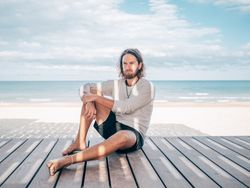 Man sitting on wooden pier on the beach