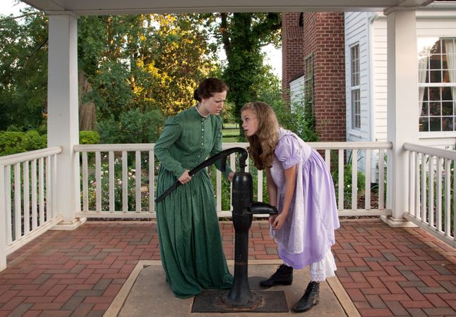 Two actors in period costume reenact scene from “The Miracle Worker”
