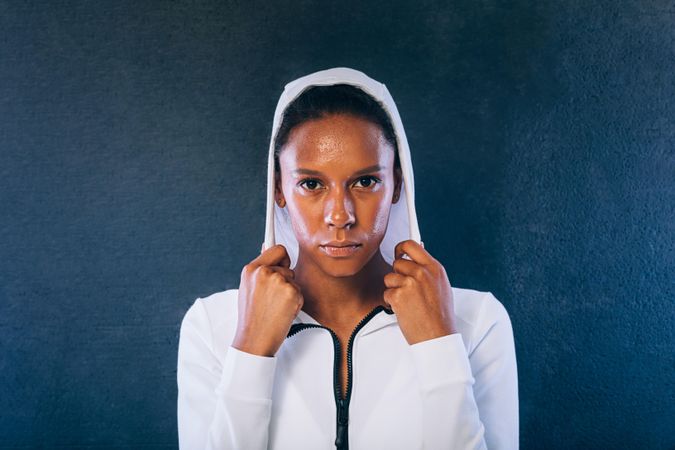 Woman in sports clothes looking at camera with hood up