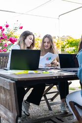 Female coworkers reviewing accounts and graphs making forecast for the next year of the company