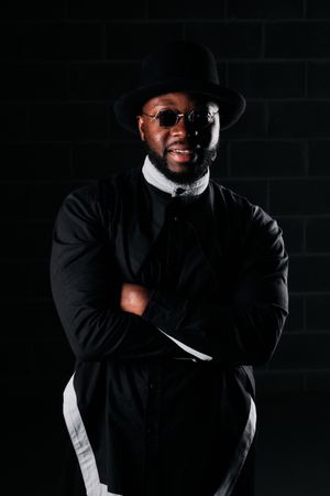 Black man in trendy outfit on dark background