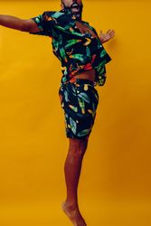 Male with opened brightly patterned shirt and open arms, vertical
