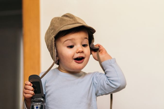 adorable baby with a hat playing with a mobile
