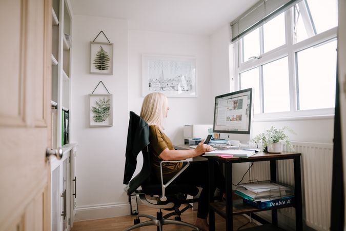 Mature woman with grey hair working from home