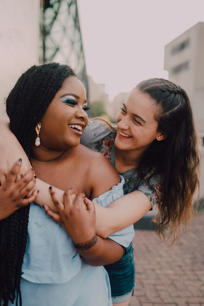 Multiethnic modern women embracing on street