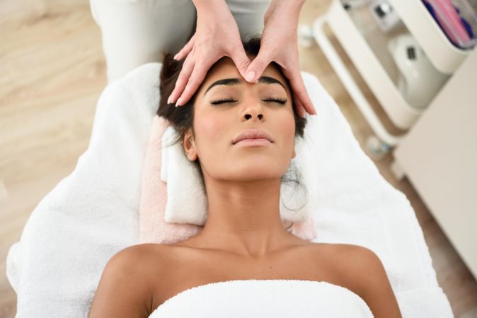 Woman receiving a facial massage from a aesthetician