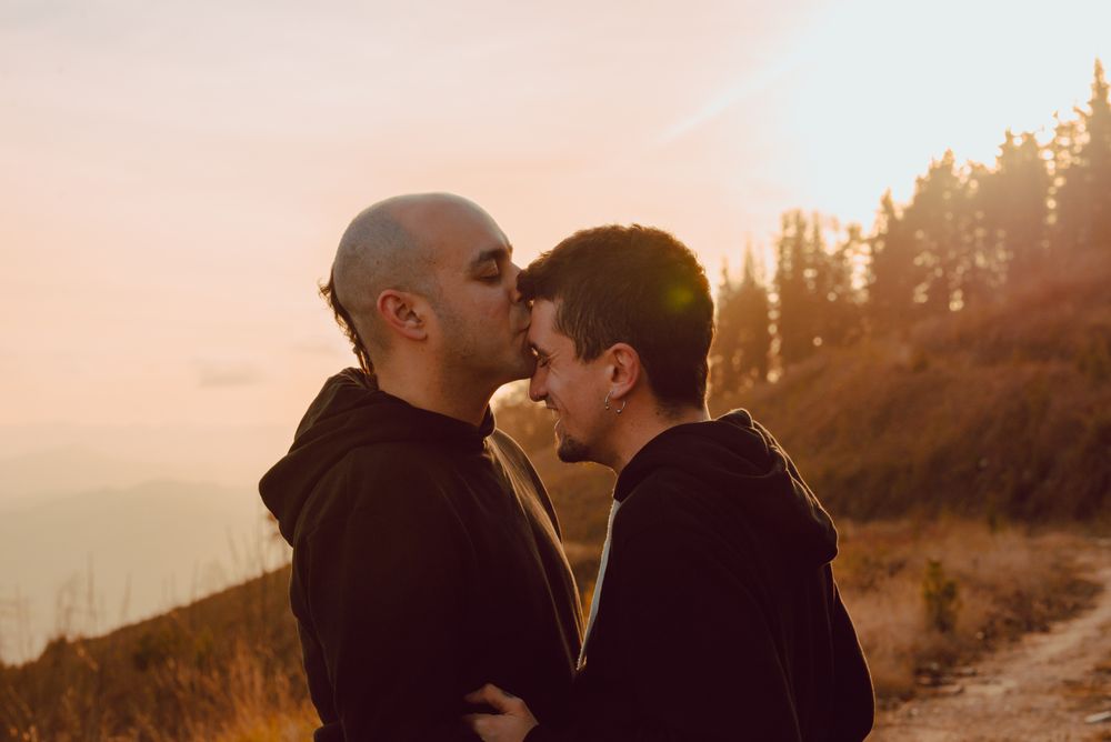 Men hugging and kissing in forest