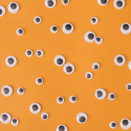 Variety of adhesive googly eyes on orange background