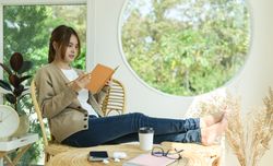 A beautiful woman reading a book in the living room at home