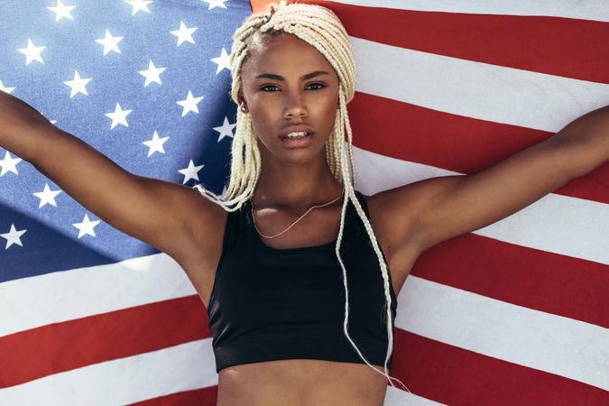 Woman athlete holding the US flag with stretched arms
