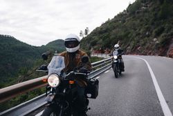 Two bike riders traveling on winding road