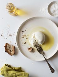 Plate with cheese near bread and condiments