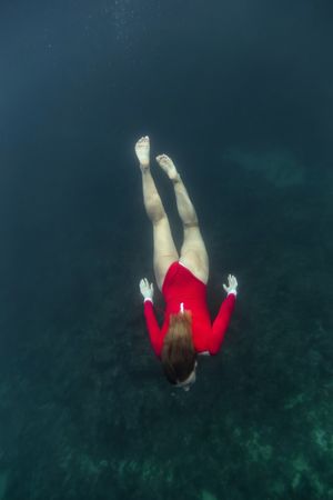 Woman diving in blue clean water