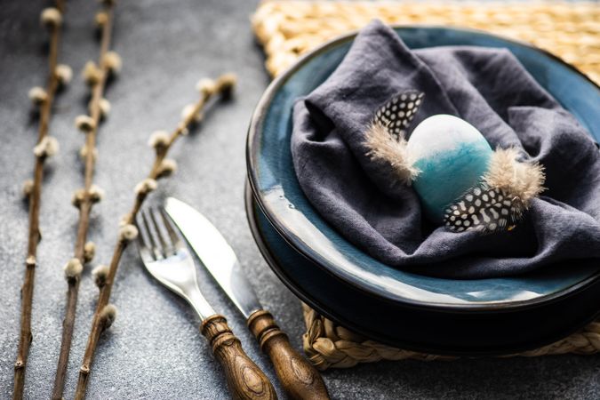 Easter holiday table setting with blue Easter egg in bowl
