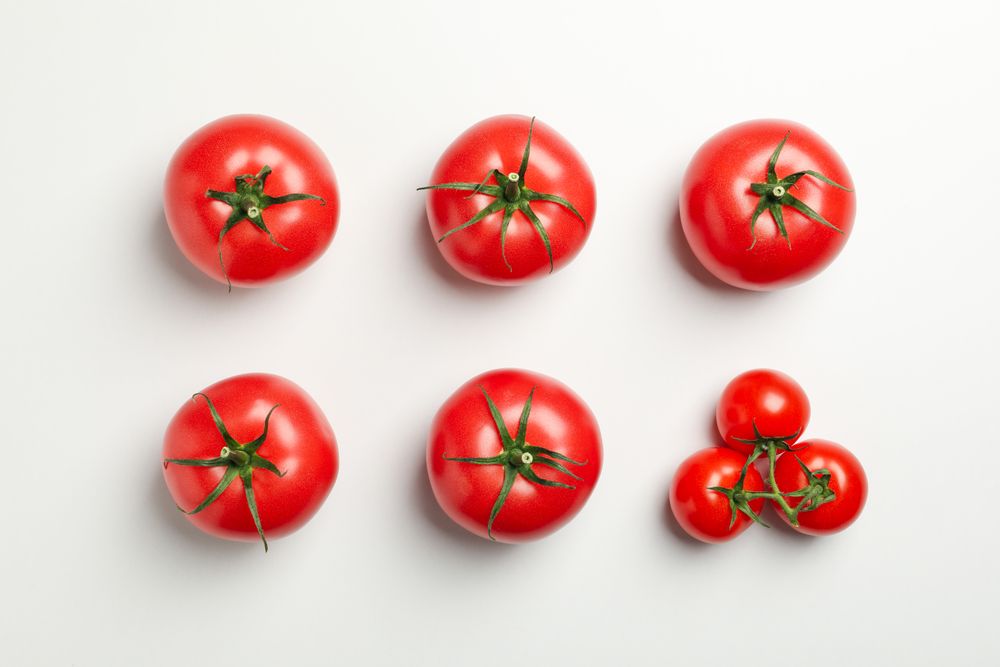Flat lay with ripe tomatoes on neutral background, top view
