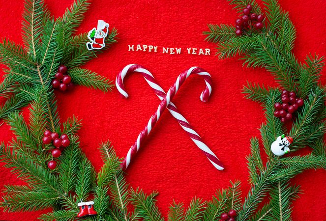 Christmas tree and candy on a red background with the words Happy New Year