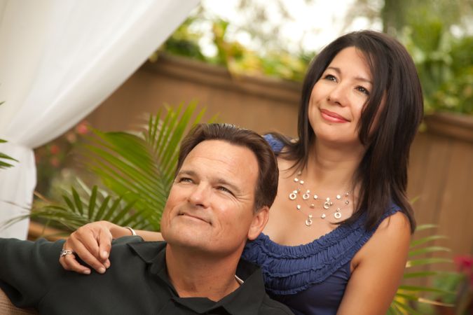 Loving Couple In Front Of Fern Looking In Distance