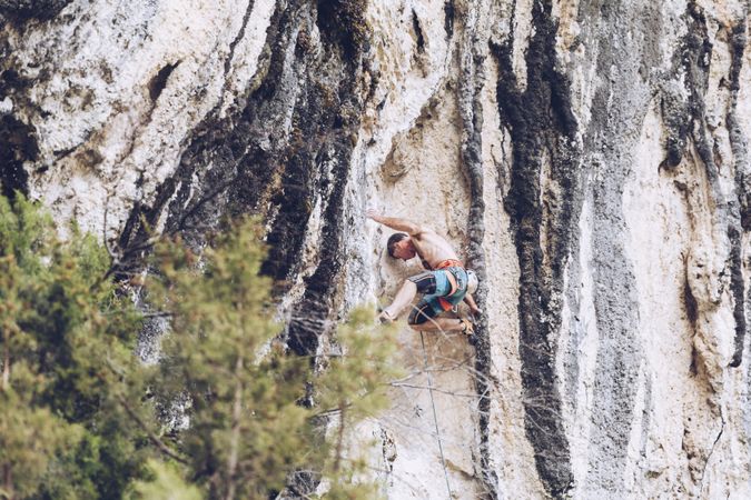 Anonymous man climbing rock