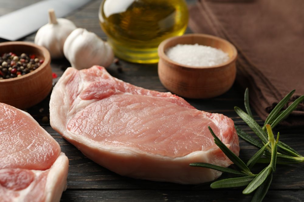 Composition with raw meat for steak and ingredients on wooden background