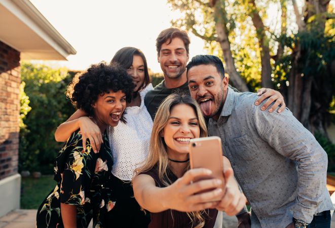 Group of people partying together and taking selfie