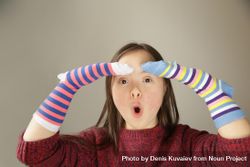 Surprised girl wearing socks on her hands beqL3b