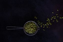 Measurement spoon filled with pumpkin seeds