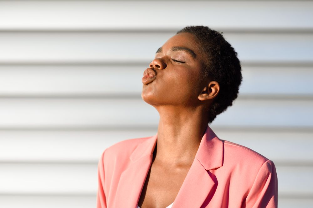 Side view of female making kissing face with eyes closed