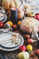 Fall table setting with squash, candles and pomegranates