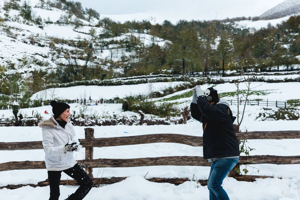 Couple having fun with snow in rural landscape